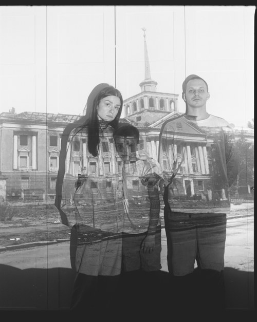 NATALIA, KAREN AND ARTEM WITH A PROJECTION OF THE BOMBED-OUT MYKOLAIV ADMIRALTY (MYKOLAIV, 2024) by Sergey Melnitchenko