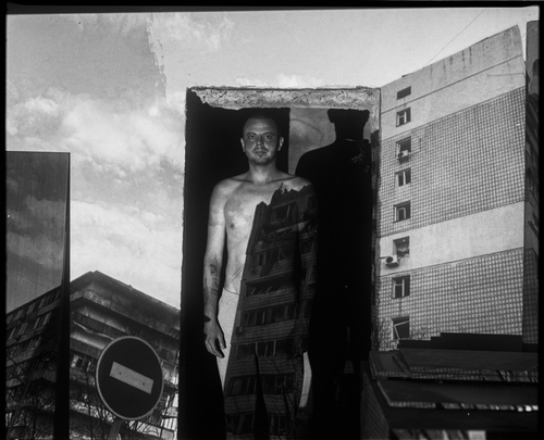 VOVA WITH A PROJECTION OF THE BOMBED-OUT NEIGHBORING HOUSE IN KYIV (MYKOLAIV, 2023) by Sergey Melnitchenko