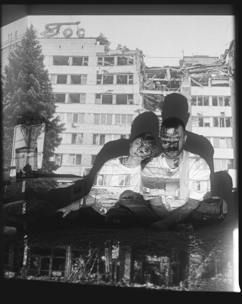 ALONA AND SERHII WITH A PROJECTION OF A BOMBED-OUT HOTEL IN MYKOLAIV (MYKOLAIV, 2024) by Sergey Melnitchenko